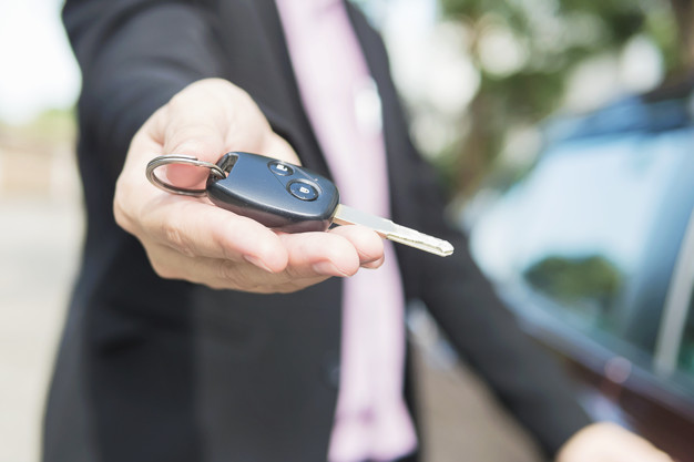 Man is giving a car key to somebody